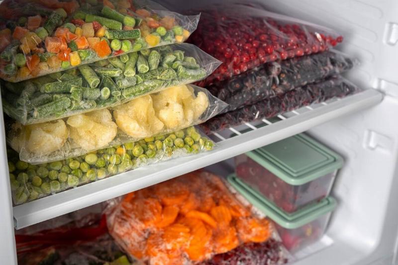 Freezer filled with bags and boxes of frozen produce