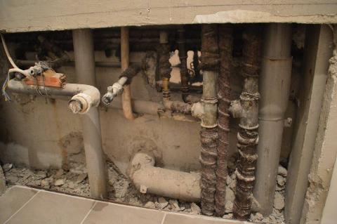 Pipes inside of torn out wall. 