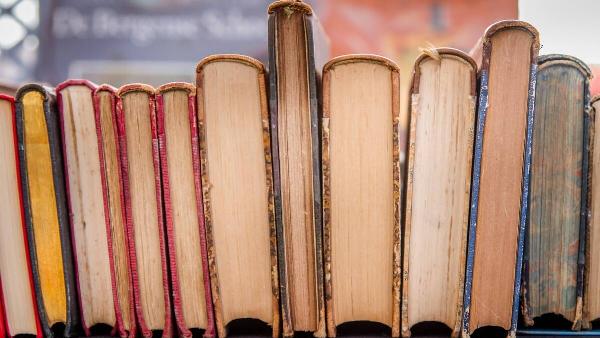 Worn, yellow books on a shelf. 