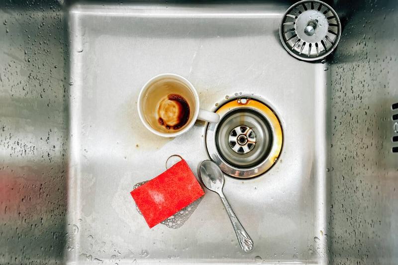 Dirty coffee cup in kitchen sink. 