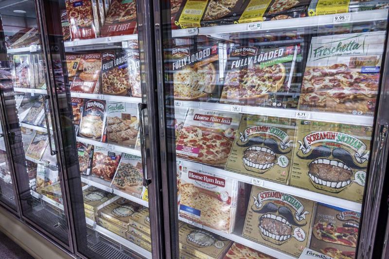 Frozen pizzas in a grocery store freezer