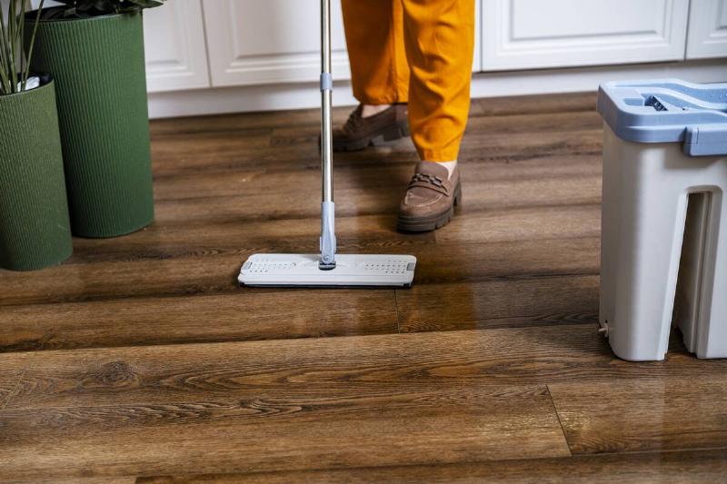 женщина-чистит-деревянный-пол-профессиональной-квартирой-m-2026-03-05-11-37-05-utc Человек моет пол шваброй.