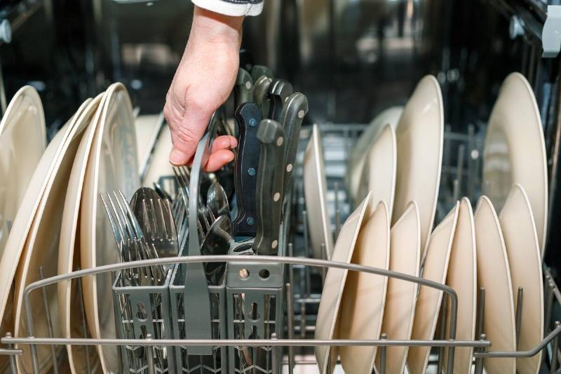 Sharp knives with the blade pointed down in a dishwasher. 