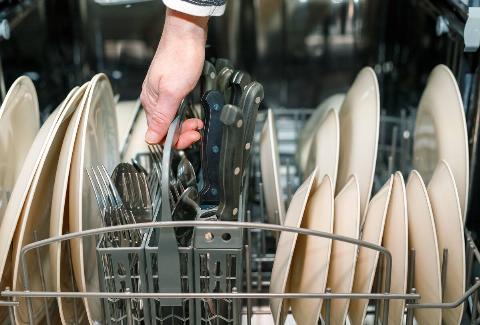 Sharp knives loaded in a dishwasher. 