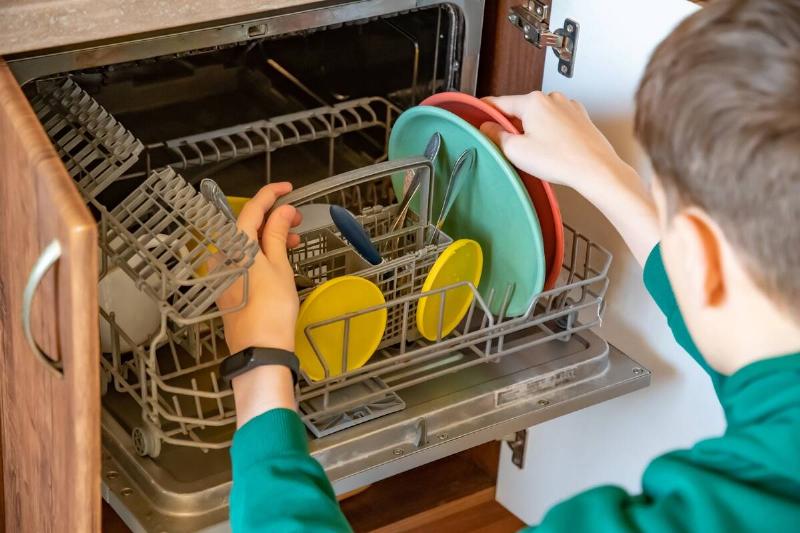A man taking dishes out of the dishwasher. 