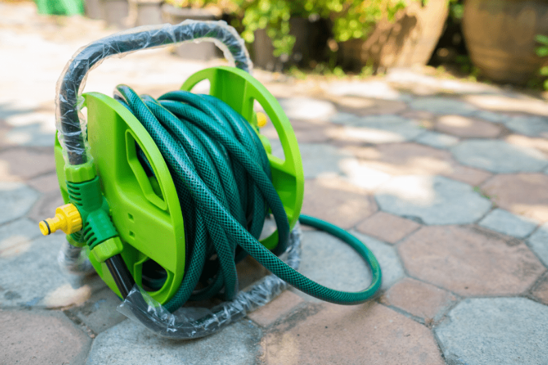 A garden hose on a stone path. 