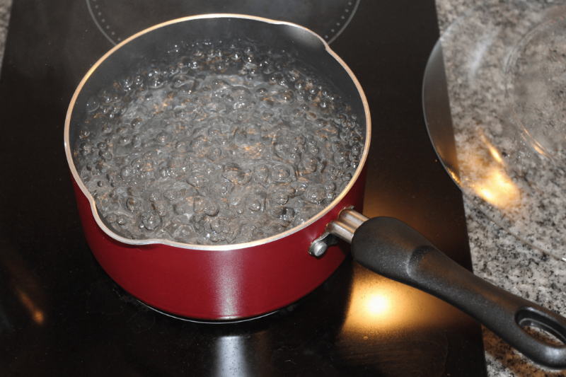 A boiling pot of water on a stove. 