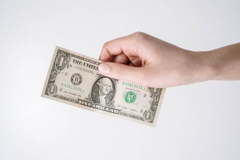 A hand holding an American dollar bill. 