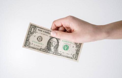A hand holding an American dollar bill. 