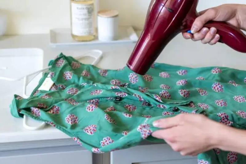 Using a hair dryer on a dress. 