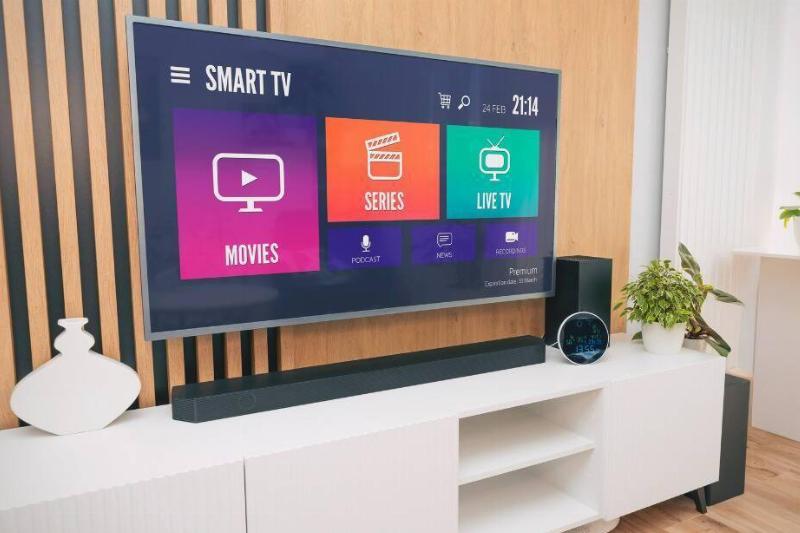 A TV on a media stand near a wall. 