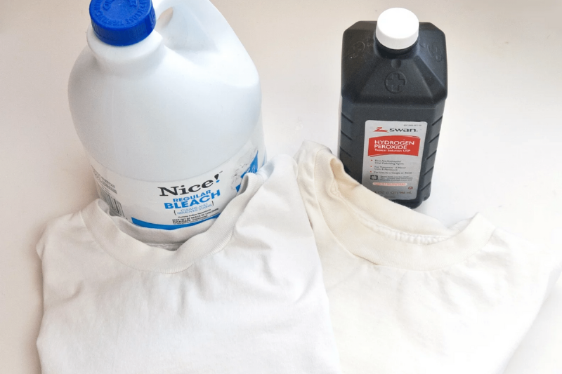 A container of bleach and hydrogen peroxide with a white shirt. 