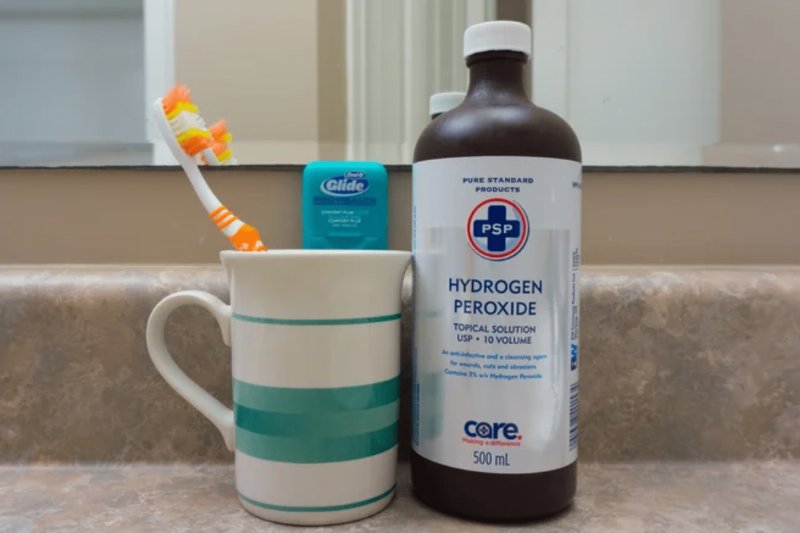 Toothbrush, floss in a cup with hydrogen peroxide. 