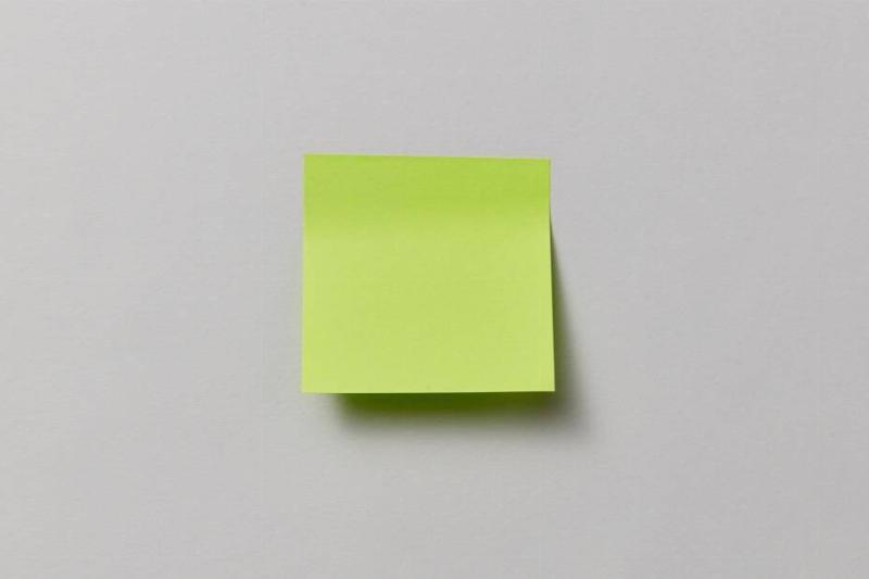 A yellow Post-It note stuck to a wall. 