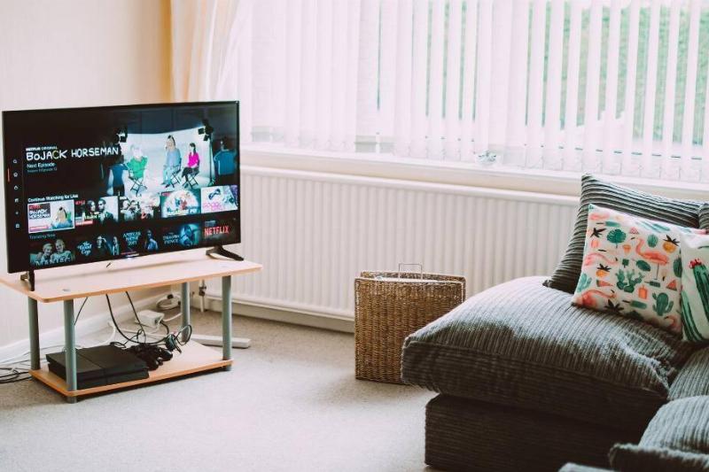 A TV on a table near a window.
