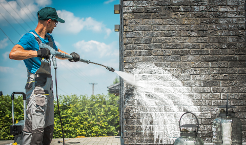 Pressure washing a brick house. 