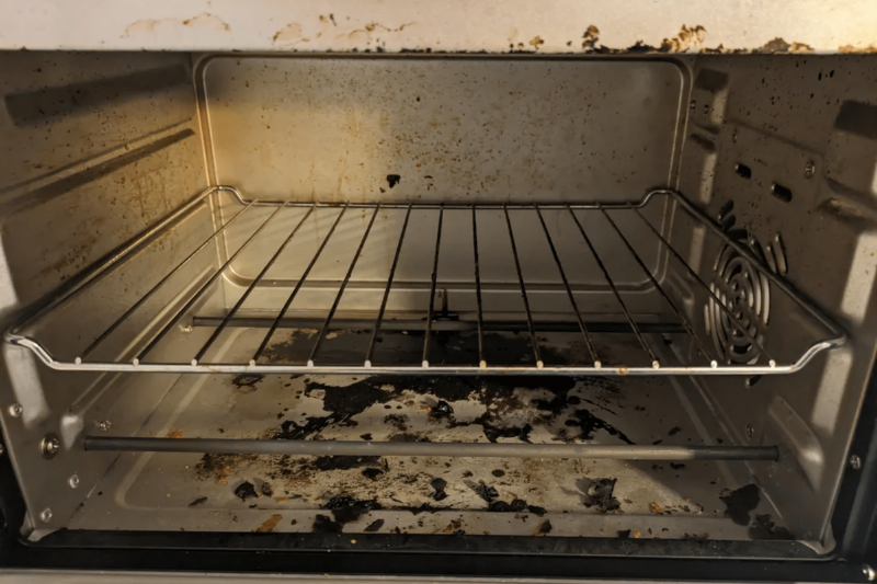A dirty inside of an oven. 