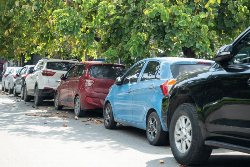 A line of cars parked on the side of a road. 