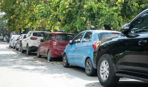 A line of cars parked on the side of a road. 