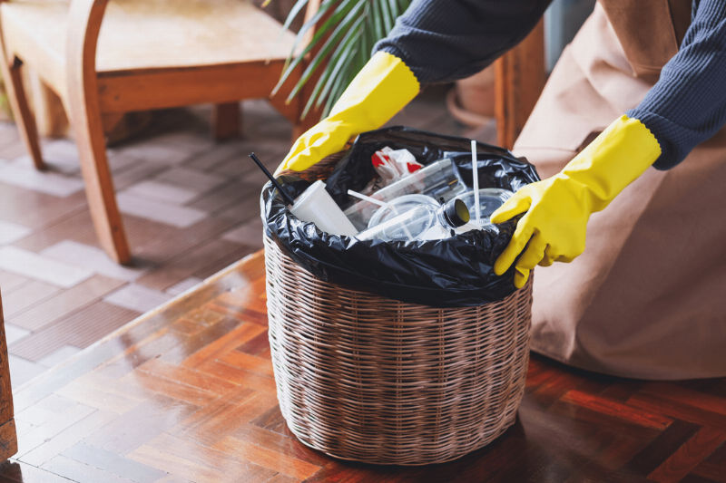 A person cleaning out a garbage can. 