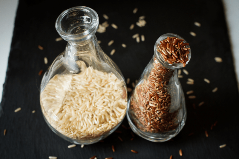 White and brown rice in glass jars.