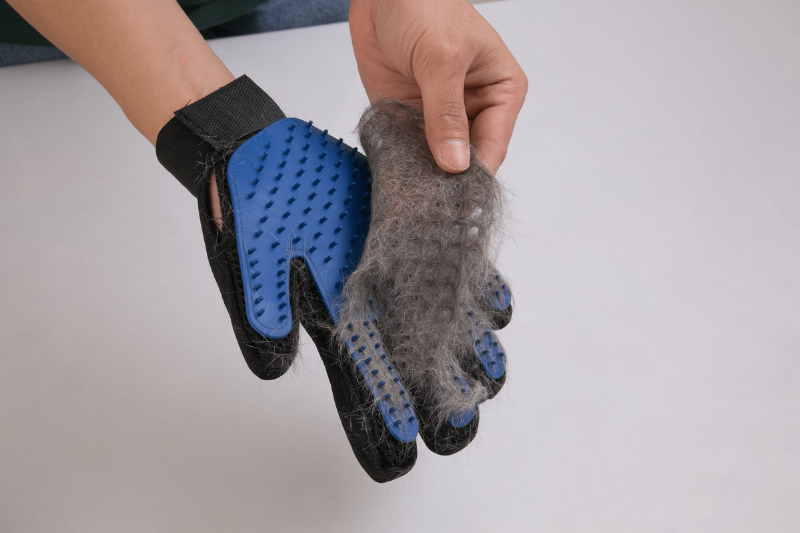 Pulling pet hair off of a brush glove.
