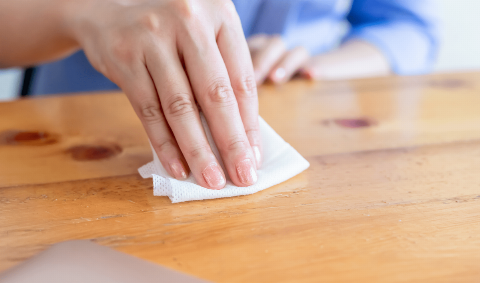 A wipe used on a wooden table. 
