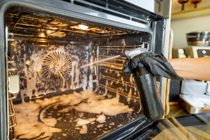Spraying cleaner into an oven. 