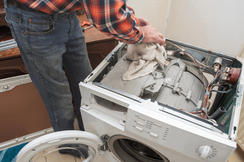 A person repairing a washing machine.