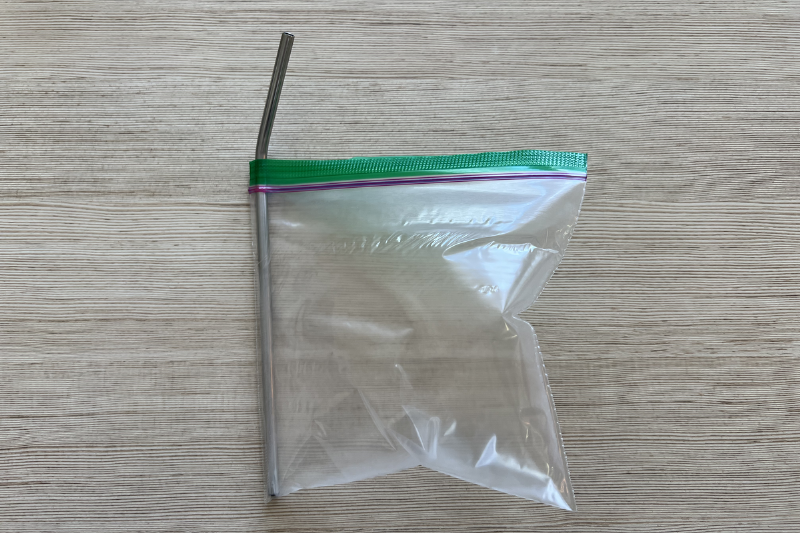 A plastic bag with a straw in it. 