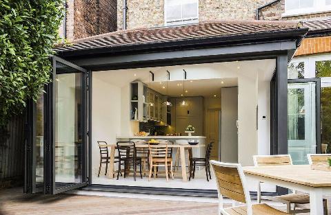 Flodable glass doors connect the interior with the garden area outside.