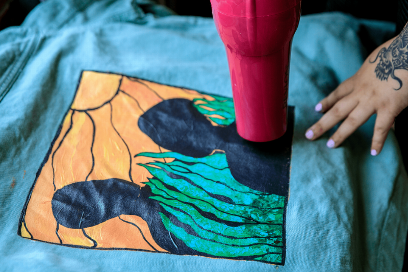 A hair dryer being used on a t-shirt design. 
