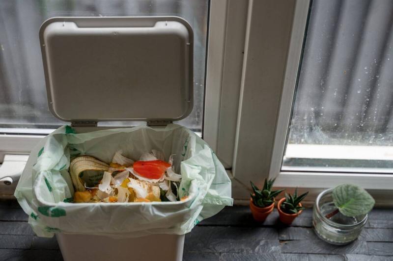 A garbage bin with food scraps in it. 