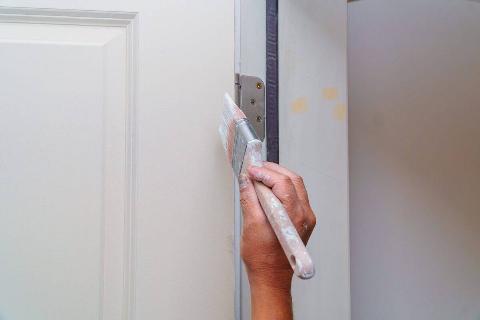 contractor-painting-a-wooden-door-white-in-a-new-h-2022-11-12-10-36-44-utc-47297-scaled-1-96222