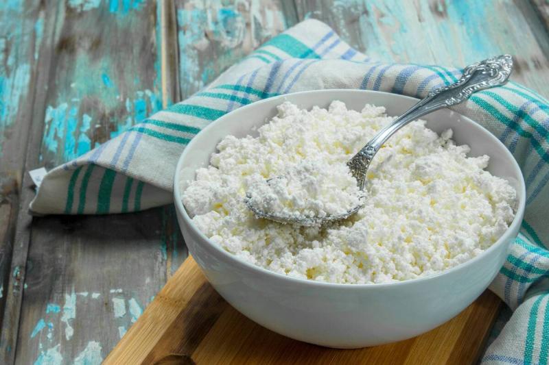 Cottage cheese in a bowl with a spoon. 