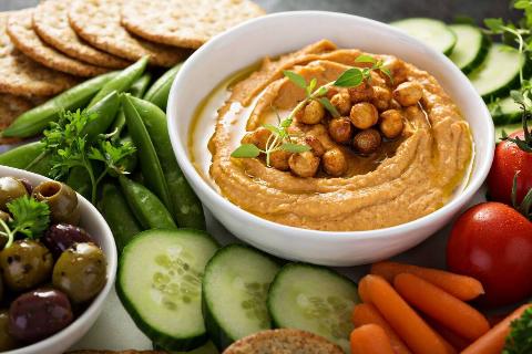 Hummus on a platter with vegetables.