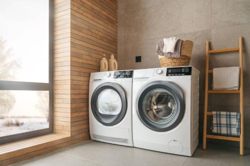 A washing machine and dryer near a window. 