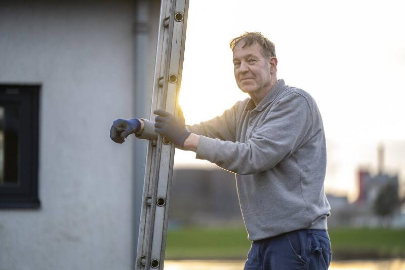 A man leaning on a ladder. 