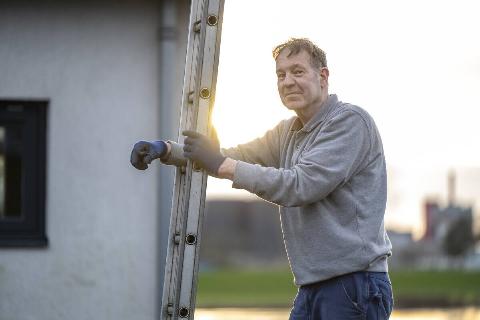 A man leaning on a ladder. 
