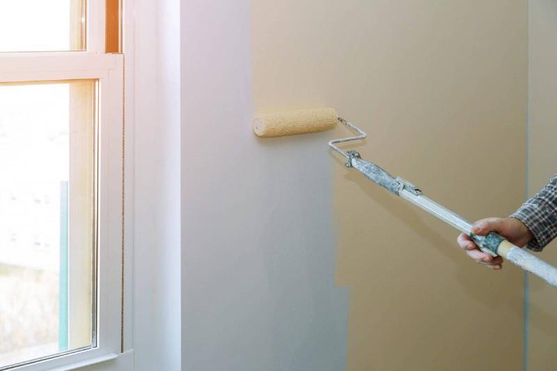 Rolling beige paint on a wall. 