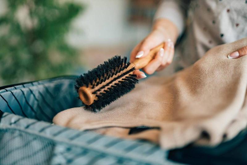 Putting a hairbrush in a bag. 