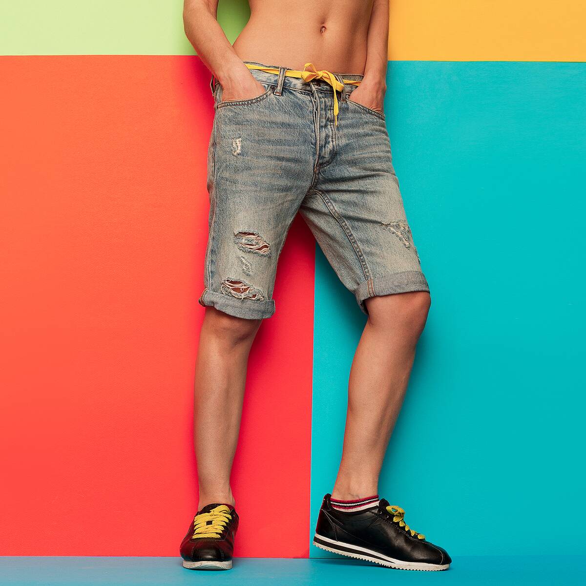A man wearing distressed jean shorts. 