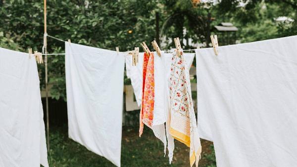 Clothes and sheets hanging on a laundry line. 