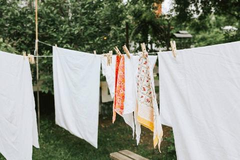 Clothes and sheets hanging on a laundry line. 