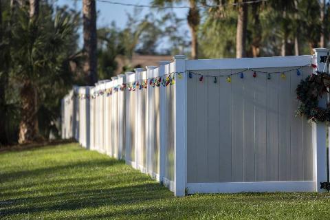Vinyl and wood fence around the perimeter of a property. 