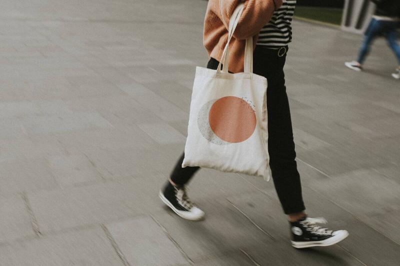A woman carrying a tote bag. 