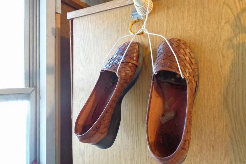 Shoes hanging on a wire hanger. 