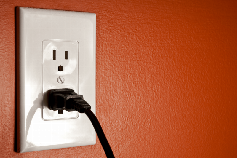 A black plug in a wall outlet.