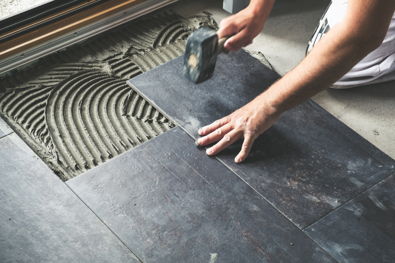 Putting tiles on the ground.