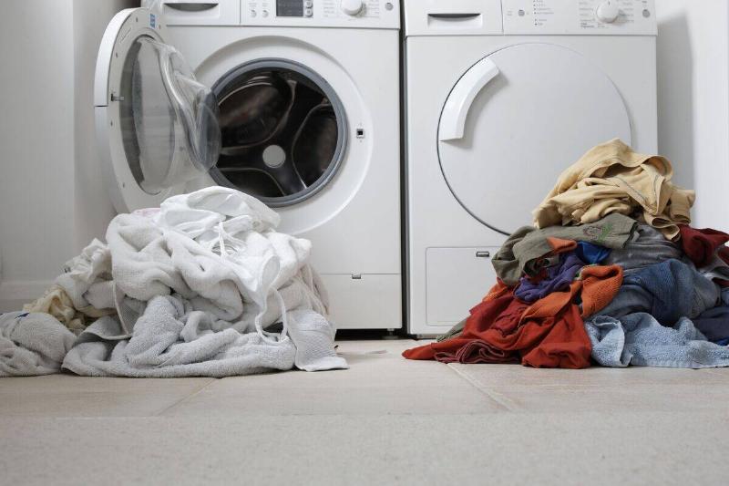Clothes in front of washer and dryer. 